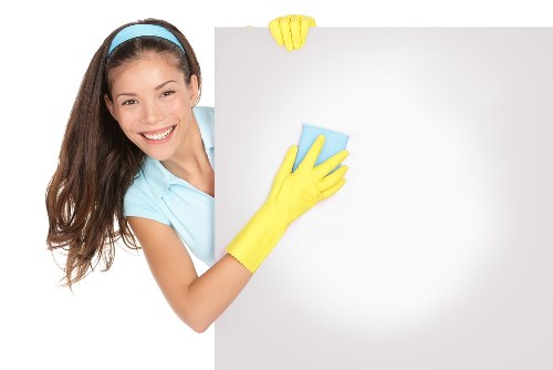Local cleaner treating stains on a sofa in a SW3 apartment
